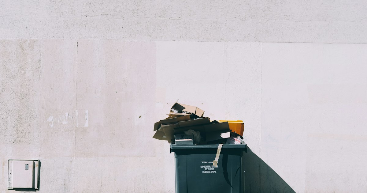 Canecas de residuos en fila sobre un andén urbano