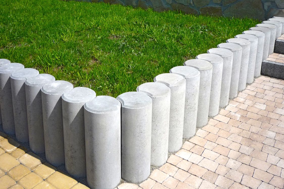 Bolardos de concreto alineados en una zona peatonal urbana